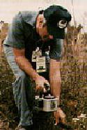 A health physicist performs an environmental contamination survey during a field exercise